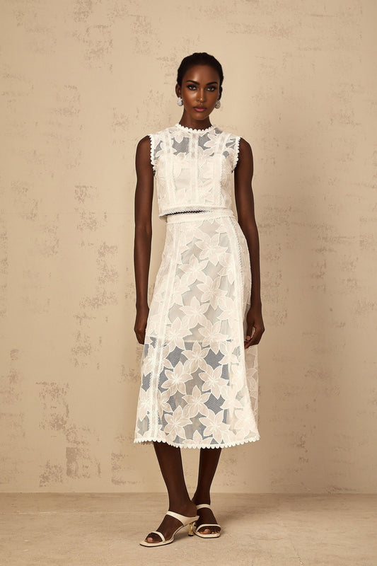A white twopiece outfit consisting of a top and skirt with floral embroidery details named Mailys