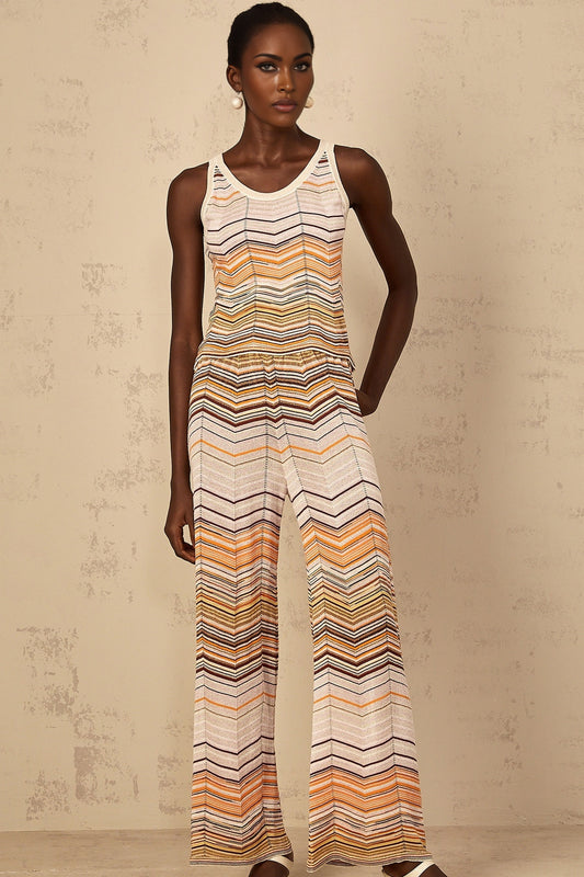 A woman wearing a beige and cream striped knit matching set consisting of a long sleeve top and wide leg pants from Chloe