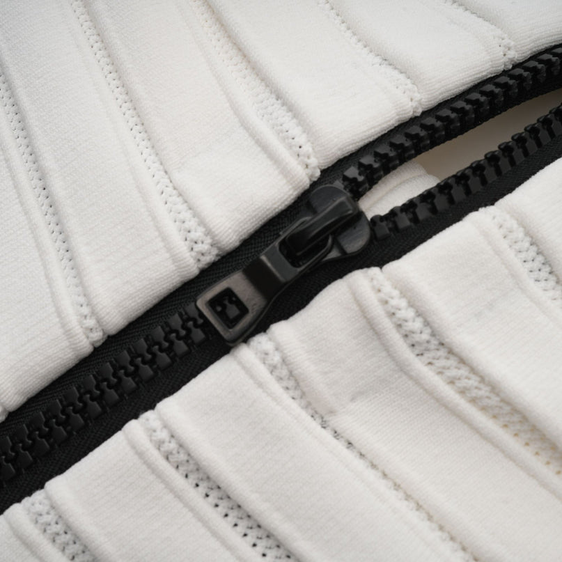 A woman wearing a black offshoulder mini dress with a bow detail on the chest The dress is made of knit fabric and has a fitted silhouette