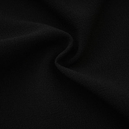Black tweed dress with notched lapels long sleeves cinched waist front bowknot detailing and contrast colors
