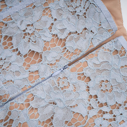 A woman wearing a blue midi dress with floral lace pattern and boned bodice