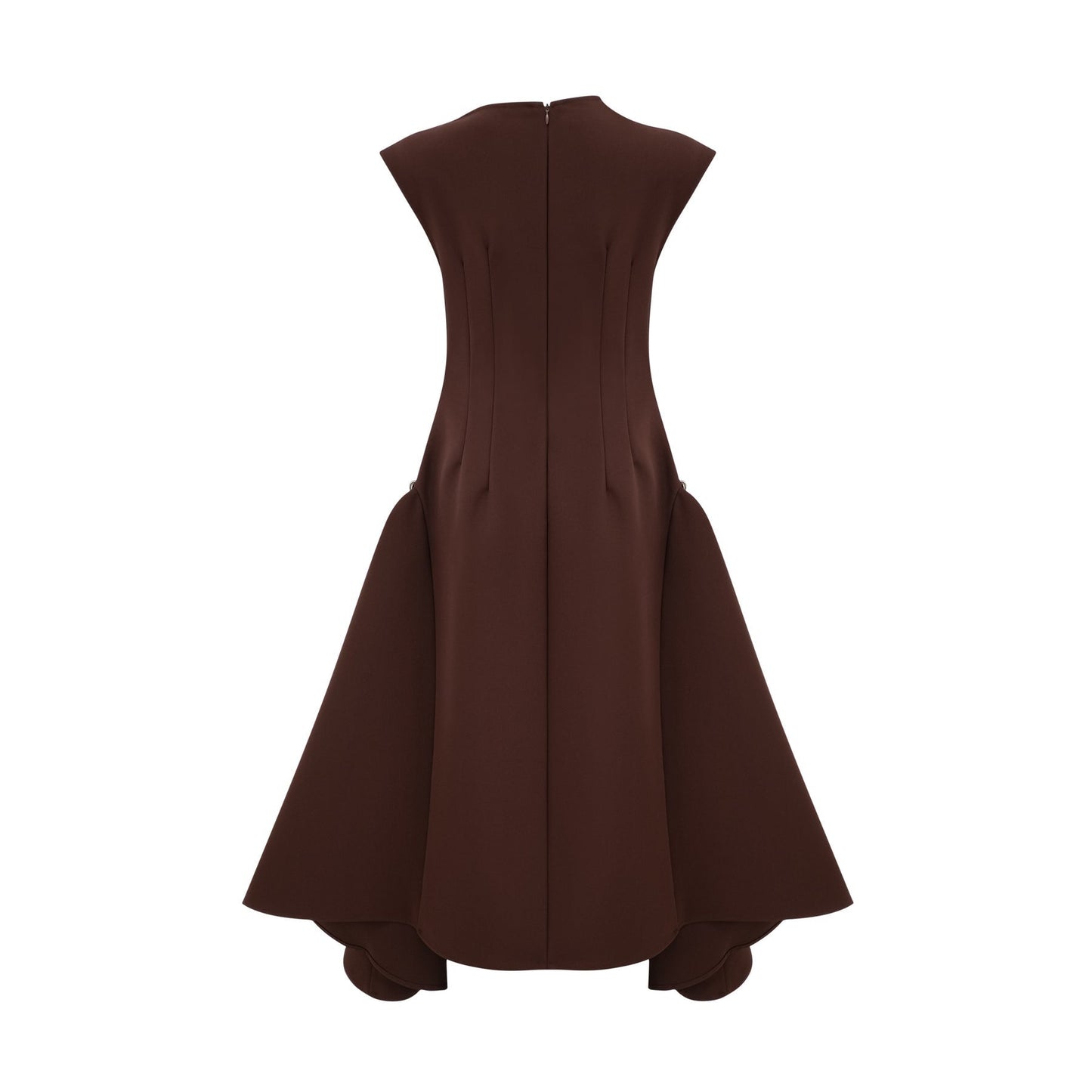 A woman wearing a brown asymmetrical midi dress with a flowing silhouette standing against a plain background