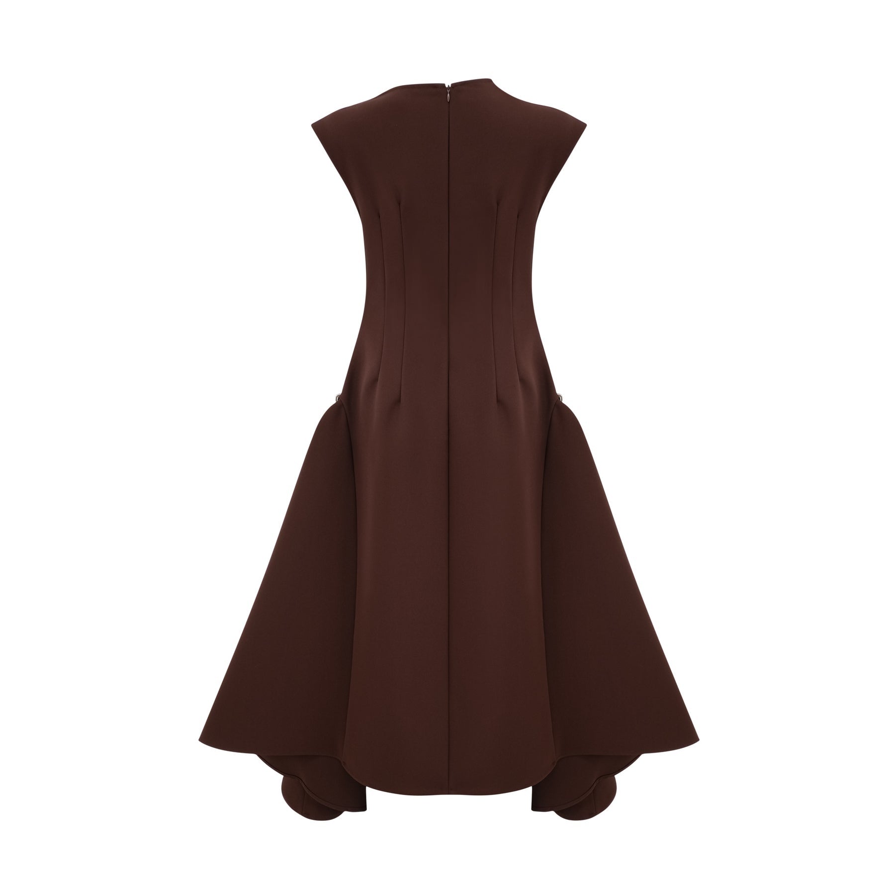 A woman wearing a brown asymmetrical midi dress with a flowing silhouette standing against a plain background
