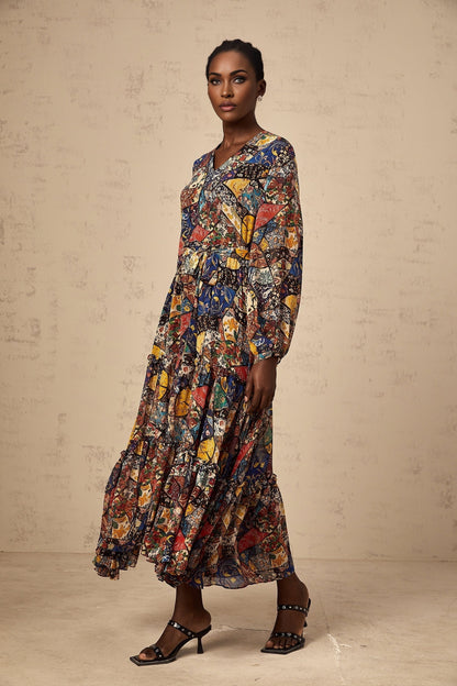A woman wearing a brown bohemian style midi dress with shirring details and a flowing silhouette