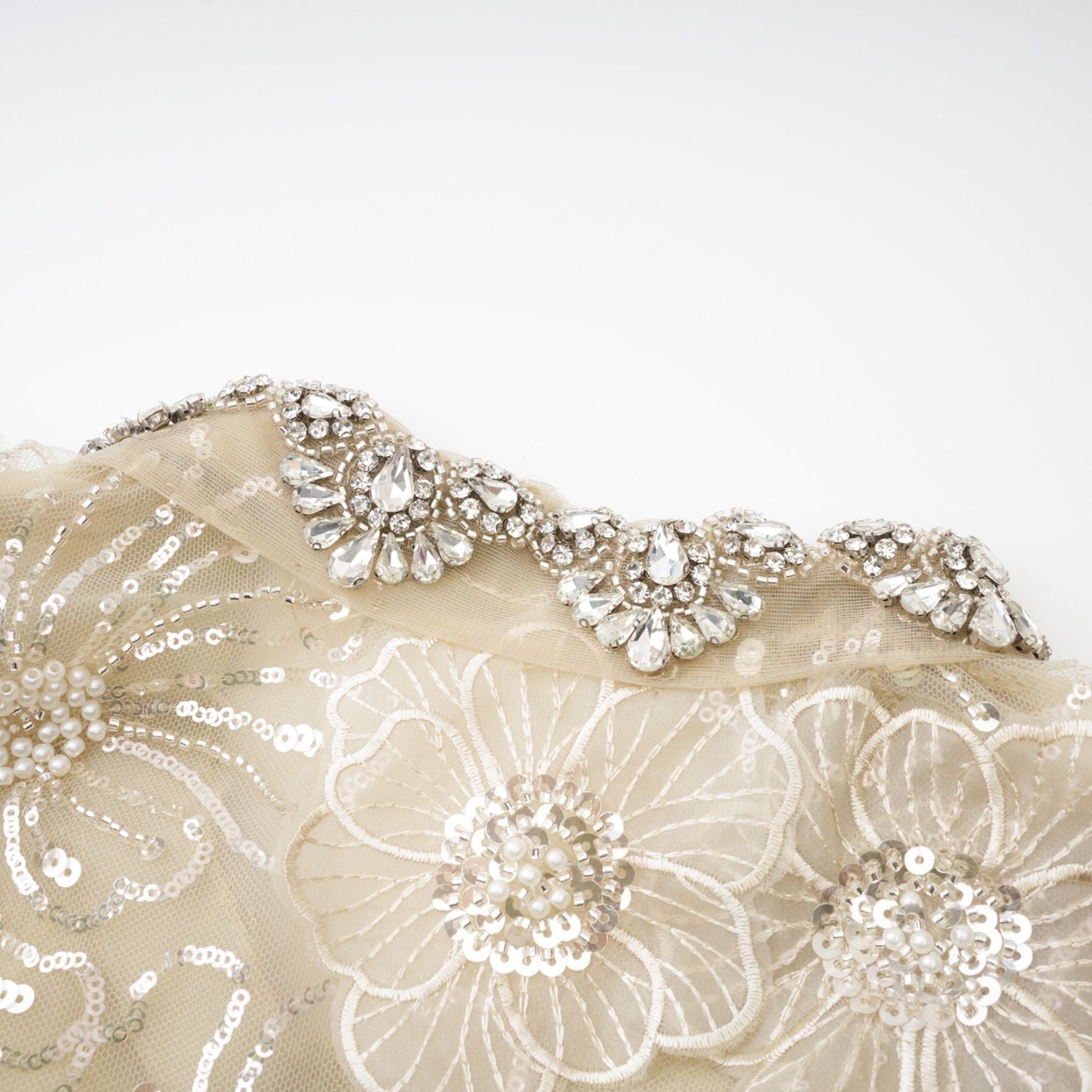 A woman wearing a delicate semi sheer jacket adorned with floral beaded patterns on organza fabric creating a light and luxurious appearance