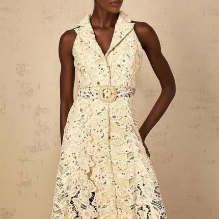 A woman wearing a floral embroidered midi dress with cutout details standing in a casual pose