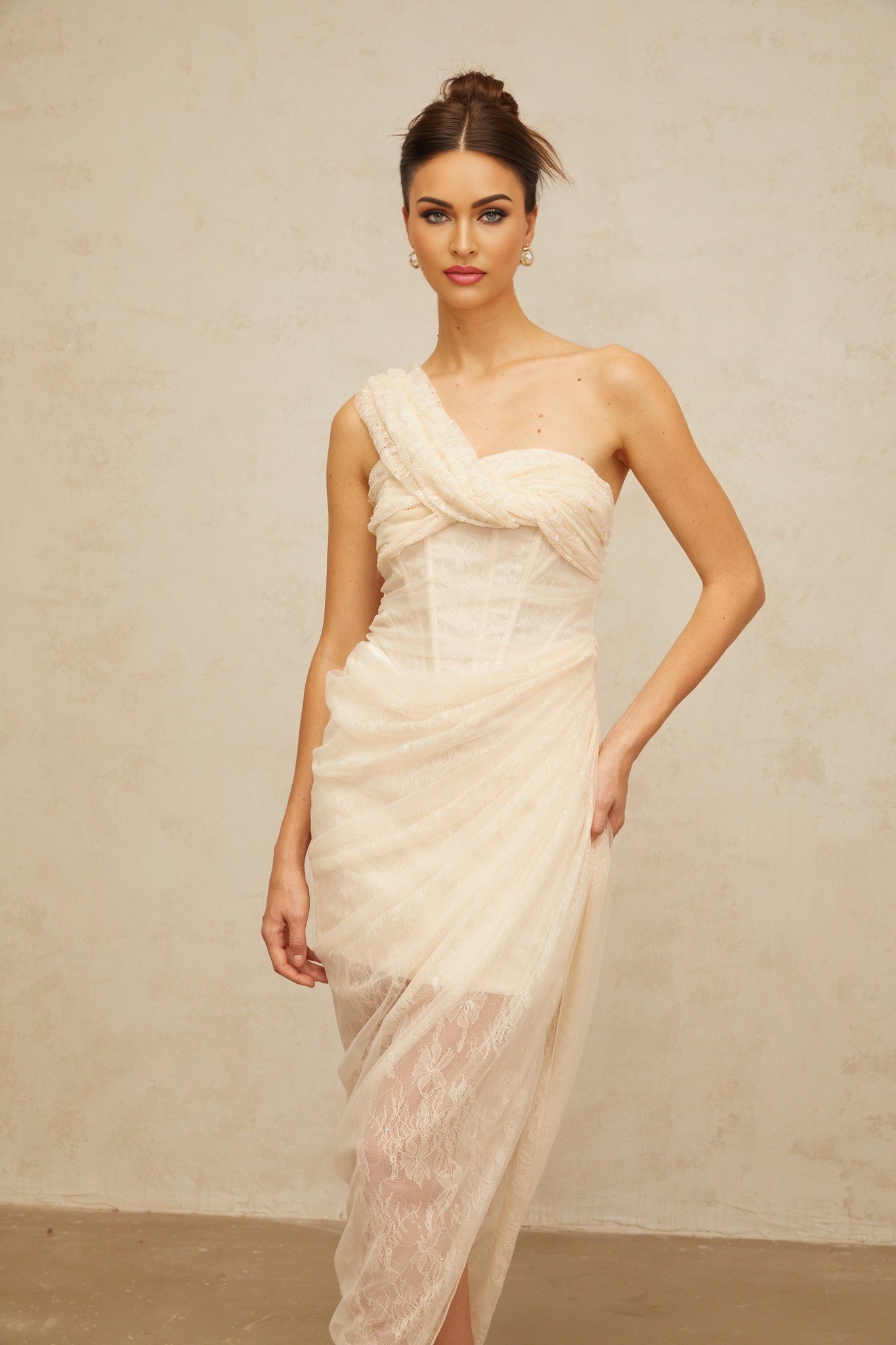 A woman wearing a floral lace midi dress with gathered tulle panels and a petuniainspired design