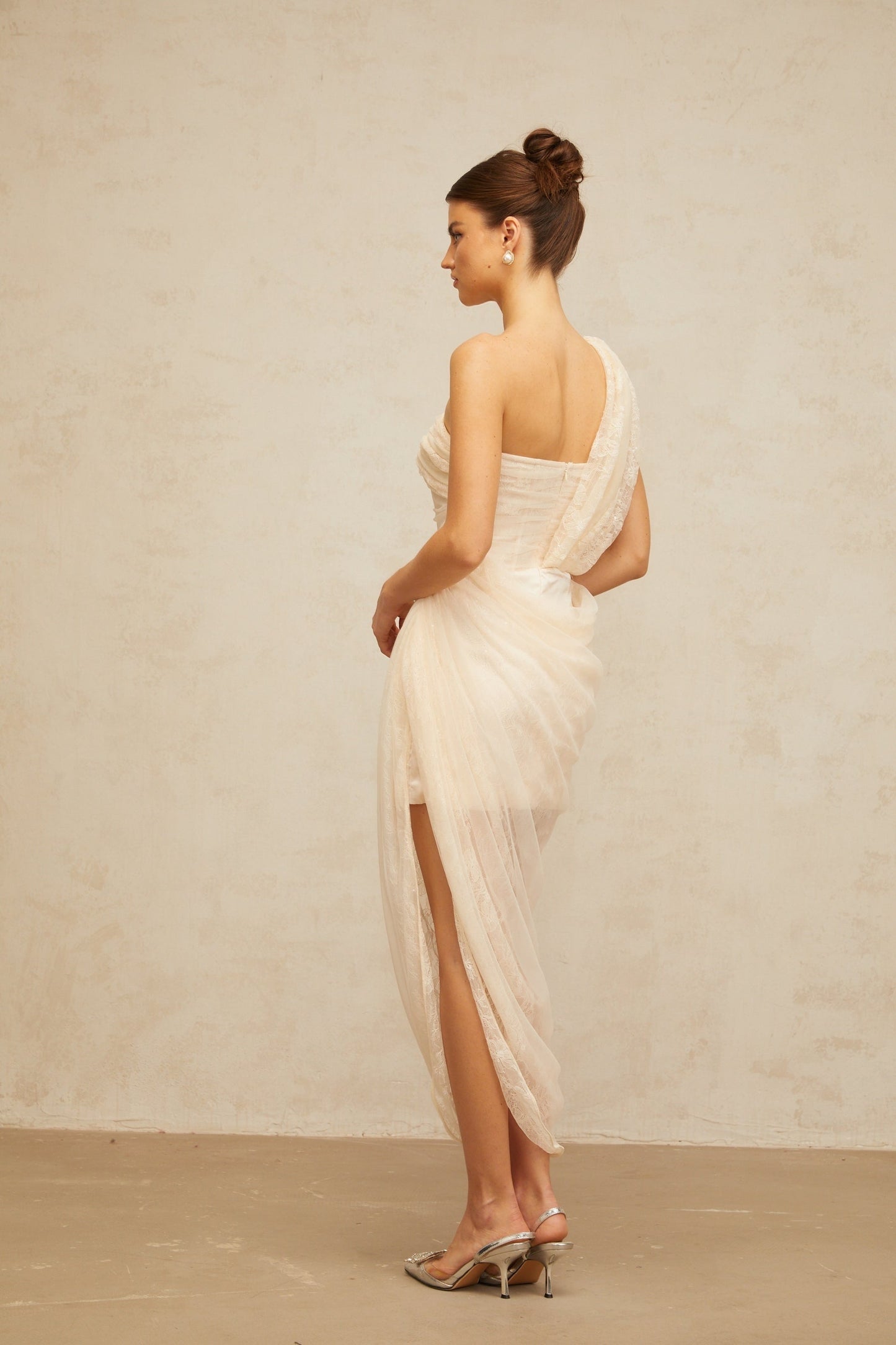 A woman wearing a floral lace midi dress with gathered tulle panels named Petunia featuring a delicate feminine design and a mid length hemline