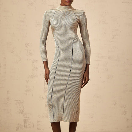 A woman wearing a gold ribbed knit midi dress with delicate pointelle details standing in a relaxed pose