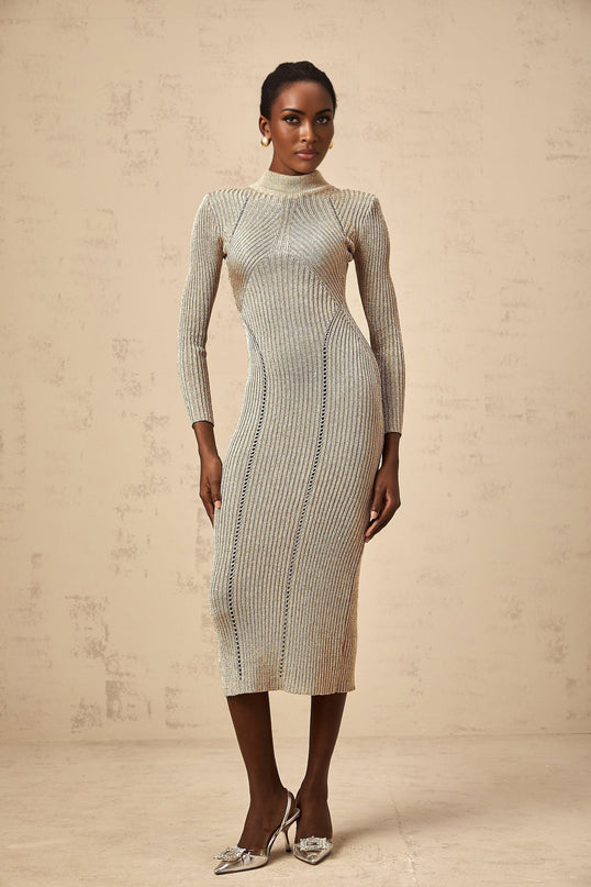 A woman wearing a gold ribbed knit midi dress with delicate pointelle details standing in a relaxed pose