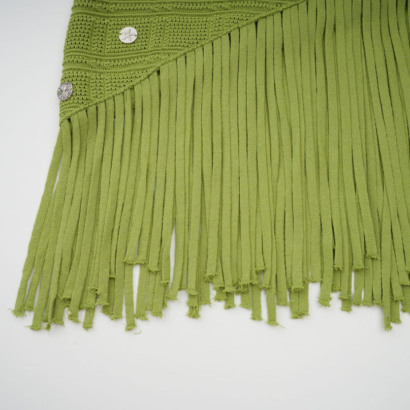 A woman wearing a green twopiece outfit consisting of a knit top and matching skirt The top is embellished and both pieces are called Annette The model stands in a relaxed pose showing off the coordinated set