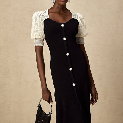 A woman wearing a knit midi dress with lace trim details along the neckline and hem standing in a neutral pose against a plain background