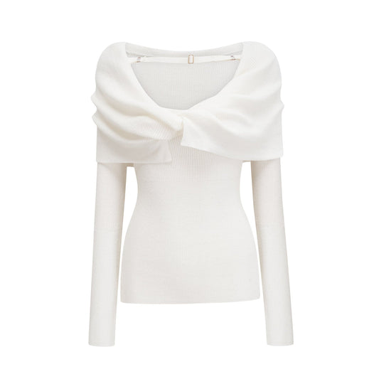 A woman wearing a lightcolored knitted strapless top with long sleeves The top has a ribbed texture and fits snugly around the chest with a straight neckline