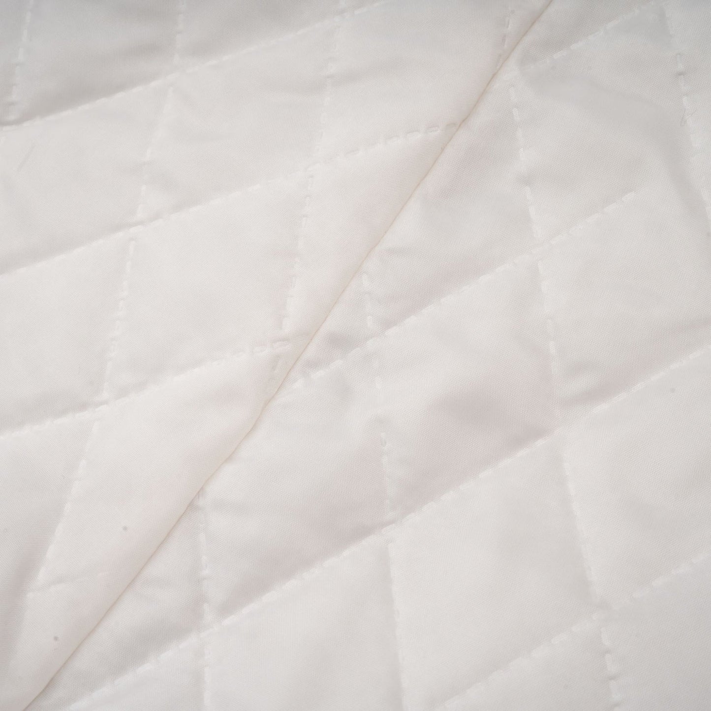 A woman wearing a long black faux fur coat with a detachable cape collar standing in a neutral pose against a plain background