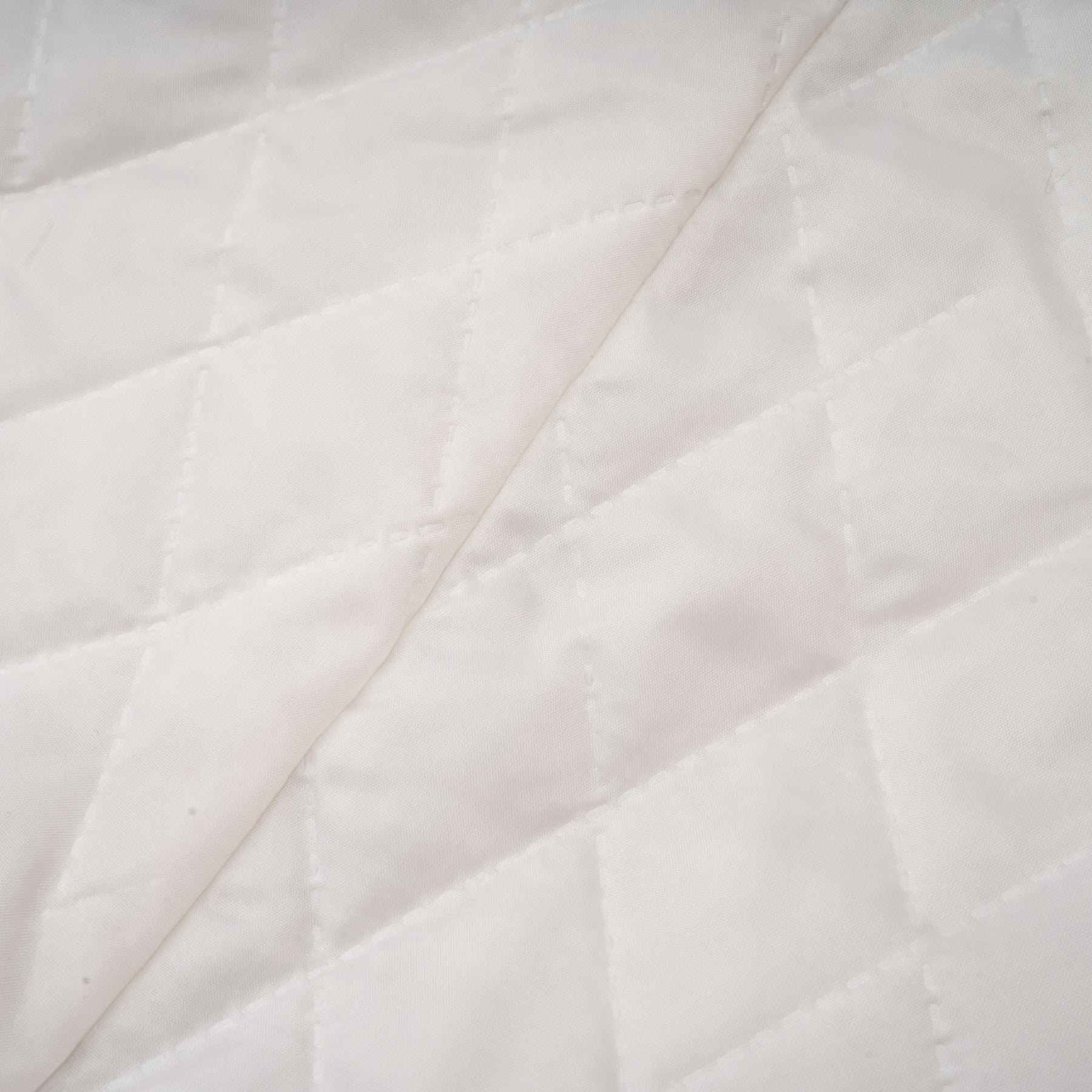 A woman wearing a long black faux fur coat with a detachable cape collar standing in a neutral pose against a plain background