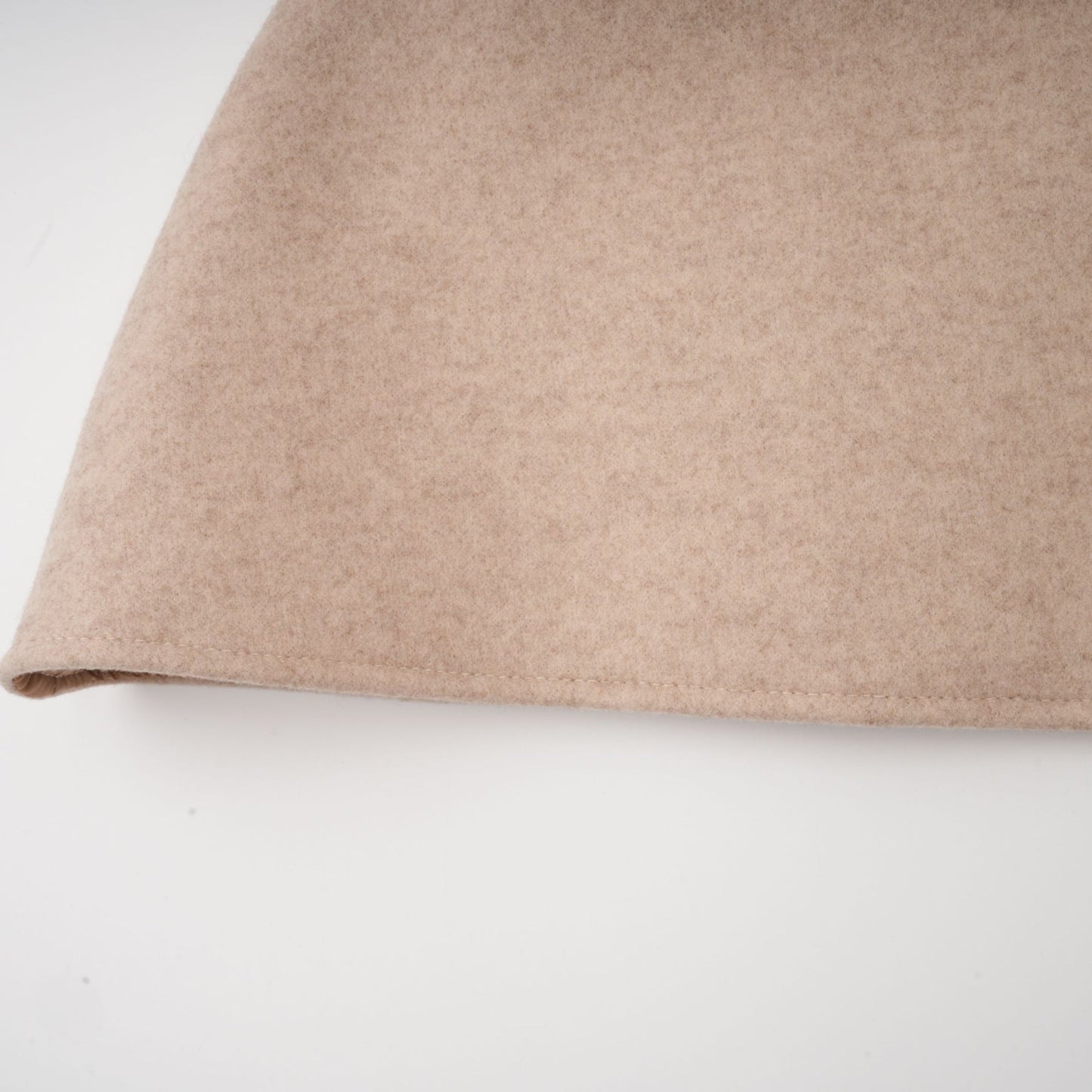 A woman wearing a long black faux fur coat with a detachable cape collar standing in a neutral pose