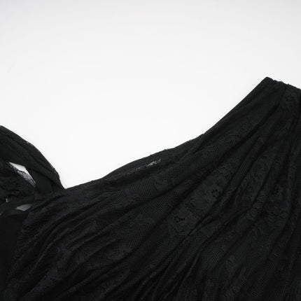 A woman wearing a long black maxi dress with a single shoulder strap and a cutout detail on one side