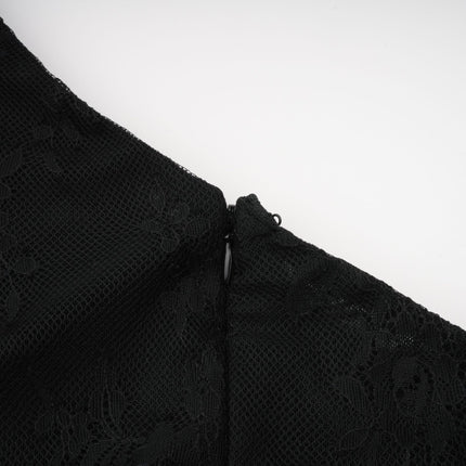 A woman wearing a long black maxi dress with a single shoulder strap and a cutout detail on one side