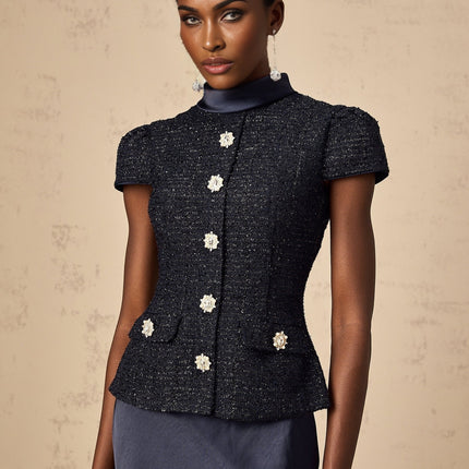 A woman wearing a long blue maxi dress with a fitted peplum waist and panelled design standing in a relaxed pose