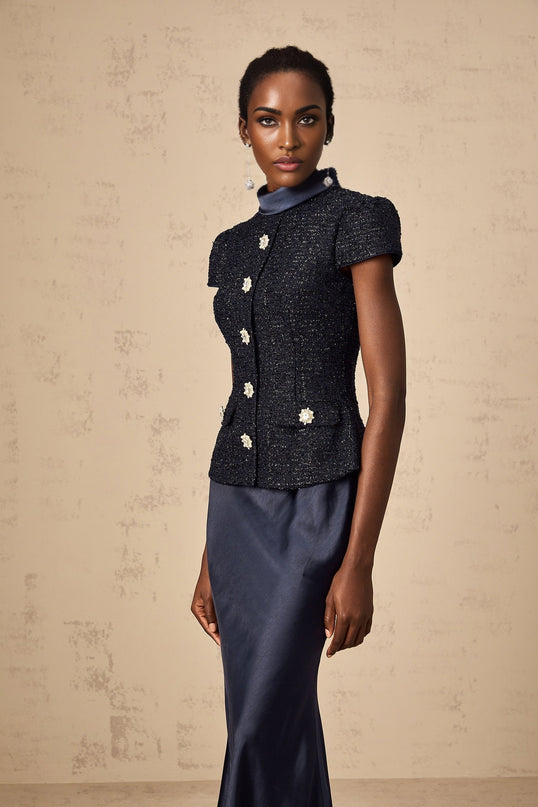 A woman wearing a long blue maxi dress with a fitted peplum waist and panelled design