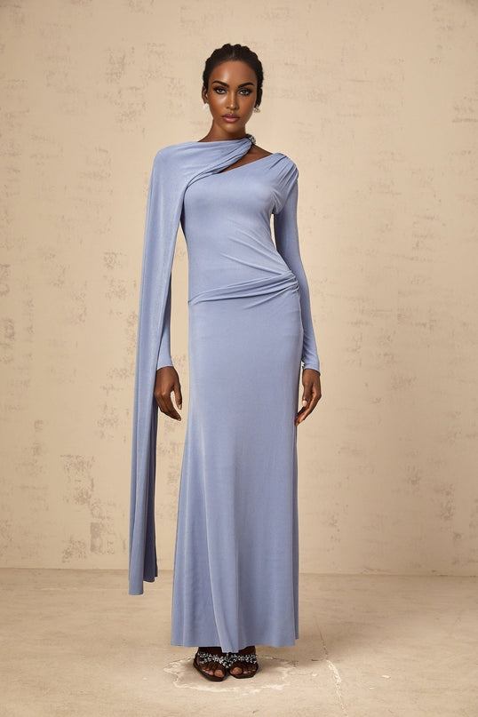 A woman wearing a long blue maxi dress with a fitted silhouette and diagonal shawl neckline