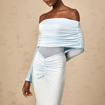A woman wearing a long blue offshoulder dress with ruched detailing and a flowing maxi skirt