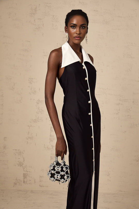 A woman wearing a long fitted maxi dress with contrasting color blocks in a stylish design