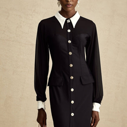 A woman wearing a long flowy maxi dress with contrasting colors and semi sheer fabric standing in a relaxed pose