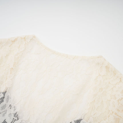 A woman wearing a long knit midi dress with lace trim details along the neckline and sleeves standing in a neutral pose against a plain background