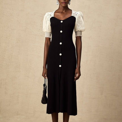 A woman wearing a long knit midi dress with lace trim details standing in a neutral pose against a plain background