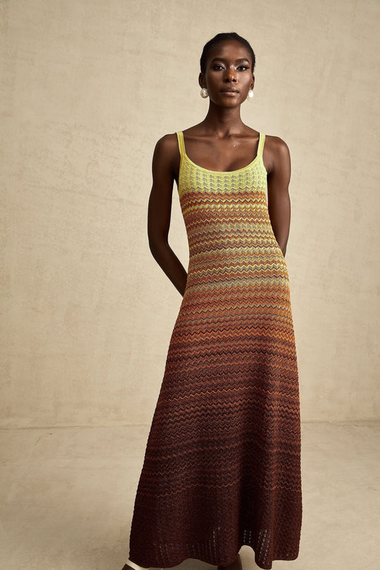 A woman wearing a long knitted maxi dress with a gradient color pattern named Audrey