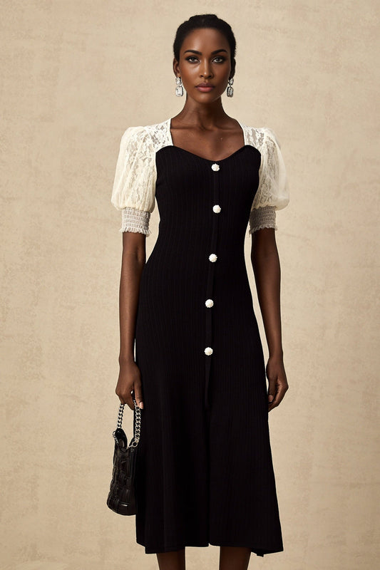 A woman wearing a long knitted midi dress with lace trim details along the neckline and sleeves standing in a relaxed pose