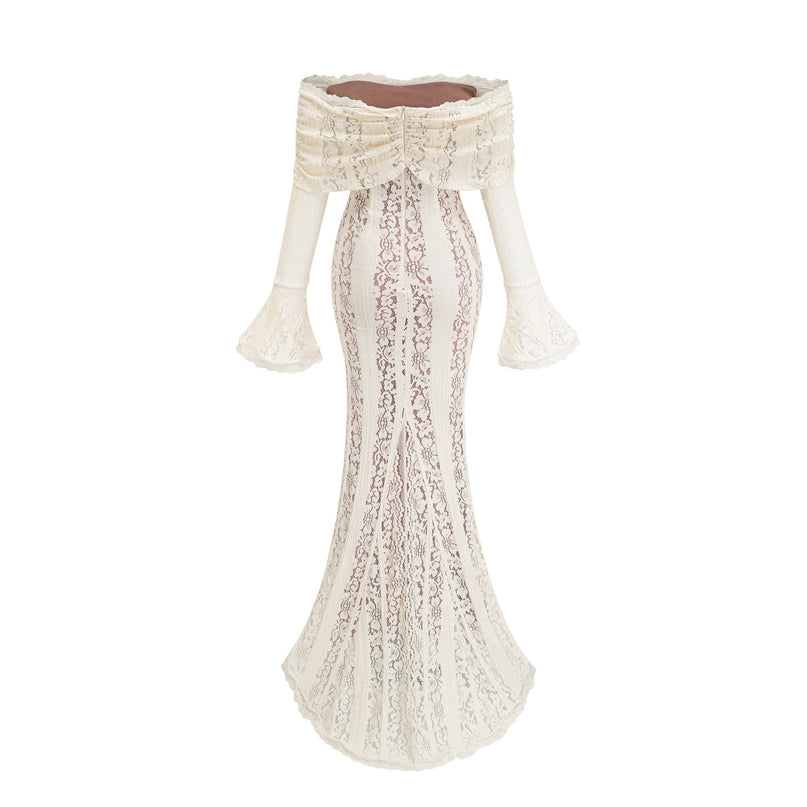 A woman wearing a long neutralcolored floral lace maxi dress with a train design standing in an elegant pose