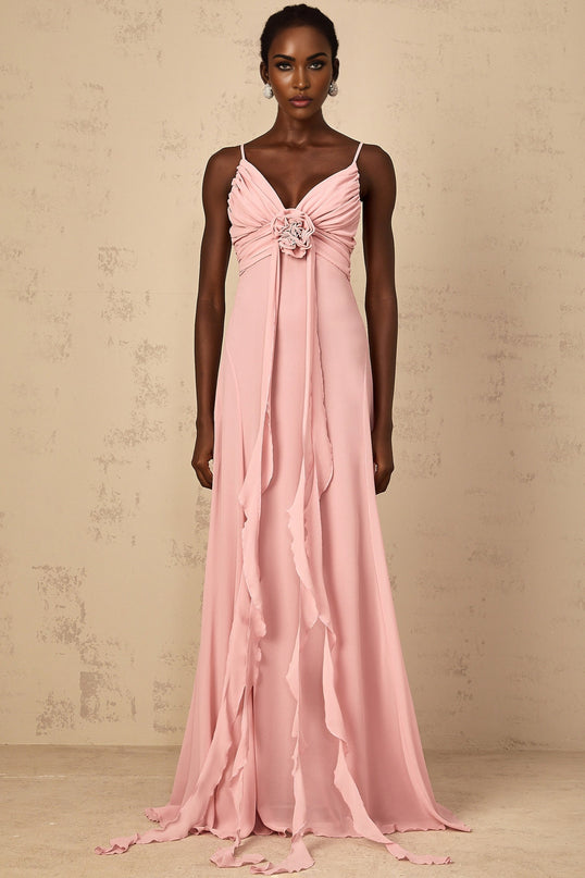A woman wearing a long pink maxi dress with 3D petal tulle details flowing elegantly to the floor