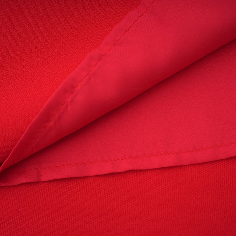 A woman wearing a long red dress with floral patterns and long sleeves