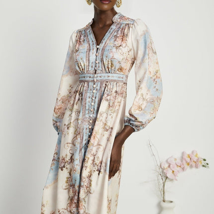 A woman wearing a long sleeve boho style dress with a floral print pattern The dress has a flowing silhouette and reaches to the ankles The model is standing in a relaxed pose showcasing the dresses bohemian aesthetic