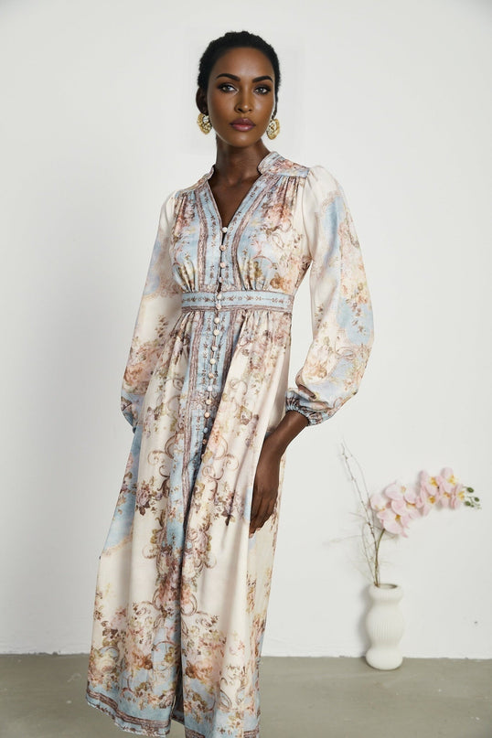 A woman wearing a long sleeve boho style dress with a floral print pattern The dress has a flowing silhouette and reaches to the ankles The model is standing in a relaxed pose showcasing the dresses bohemian aesthetic