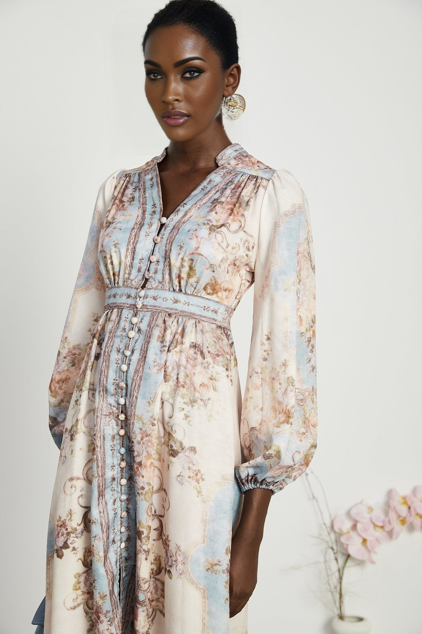 A woman wearing a long sleeve floral print bohemian style dress with a flowing silhouette and vibrant colors
