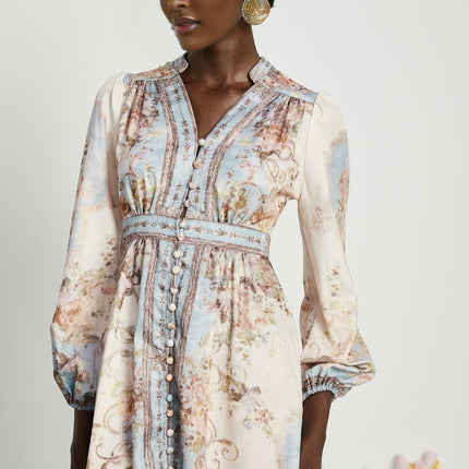 A woman wearing a long sleeve floral print boho dress with a flowing skirt and bohemian style details