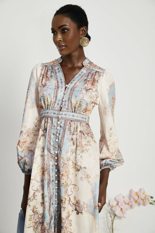 A woman wearing a long sleeve floral print boho dress with a flowing skirt and bohemian style details