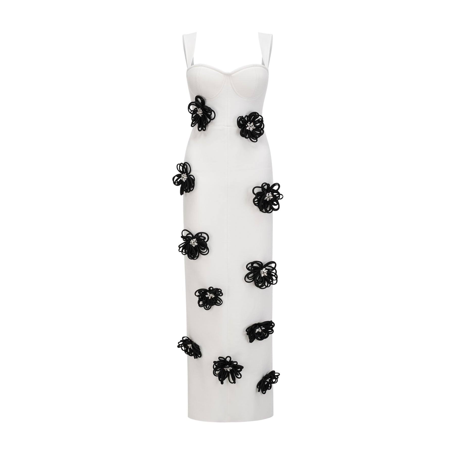 A woman wearing a long white bandage dress with floral applique detailing standing against a plain background