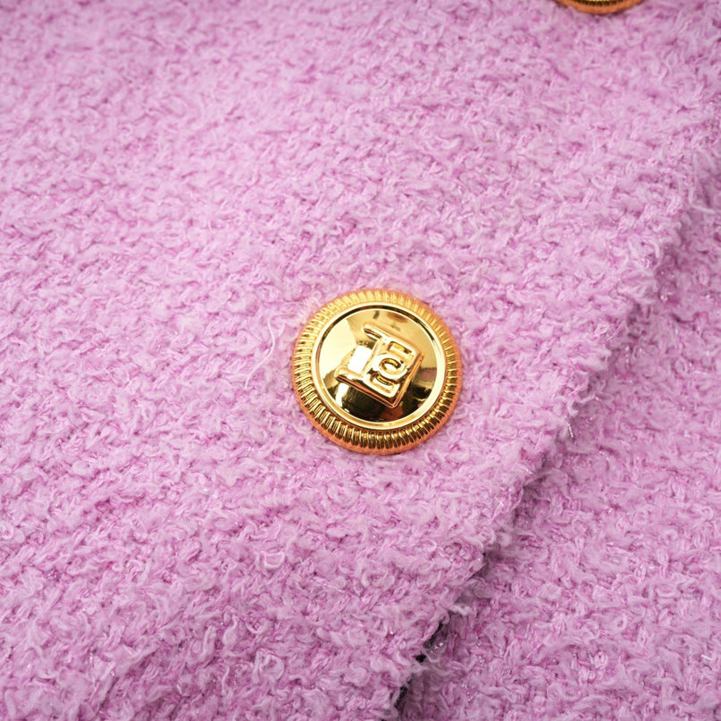 A woman wearing a matching blazer and skirt set in a professional style The outfit is likely in a solid color and has a tailored fit suitable for office or formal occasions