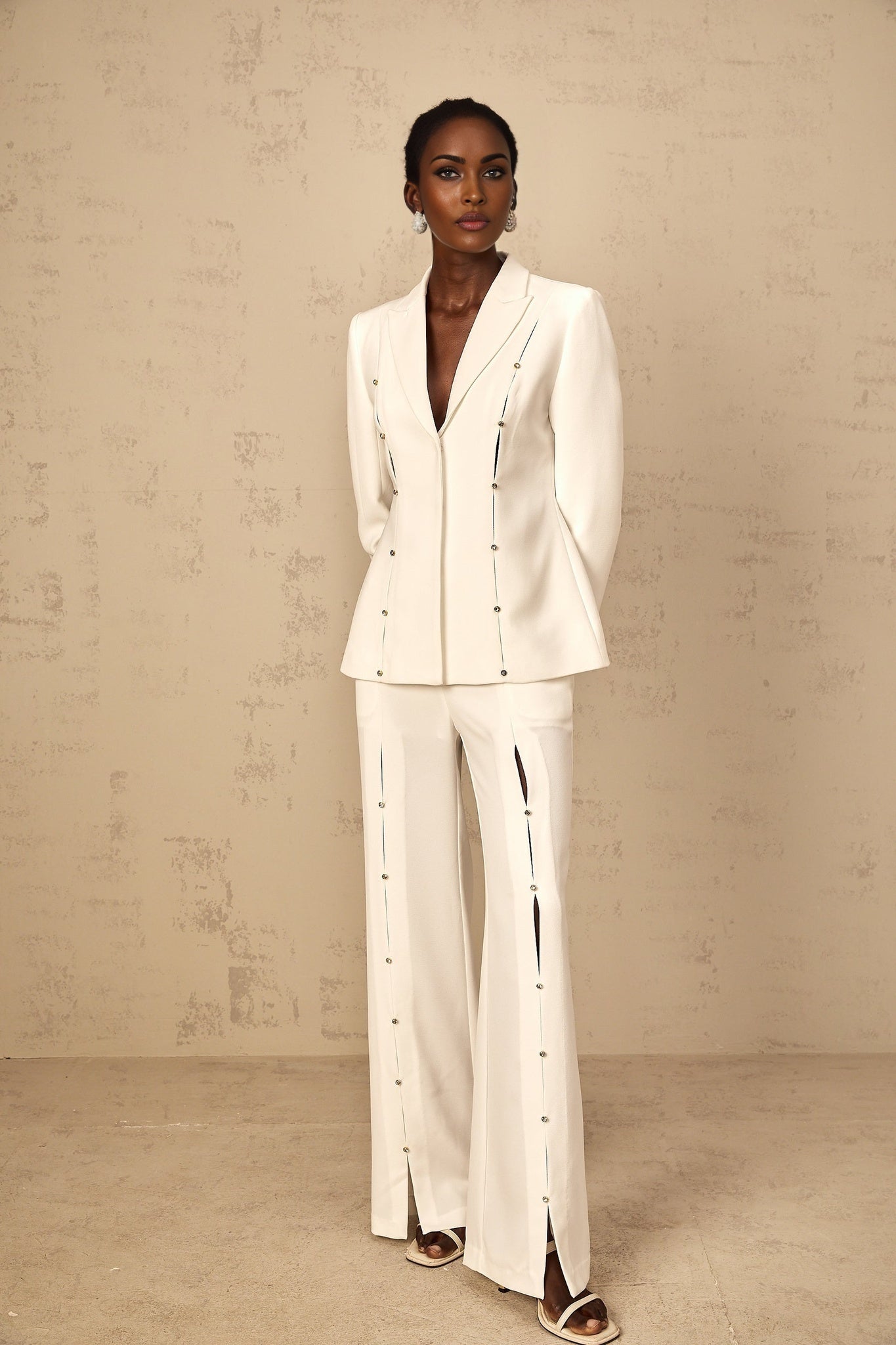 A woman wearing a matching blazer and trouser pant set The outfit is embellished and appears elegant The blazer has a tailored fit and the pants are full length The set is likely in a solid color possibly named Frida