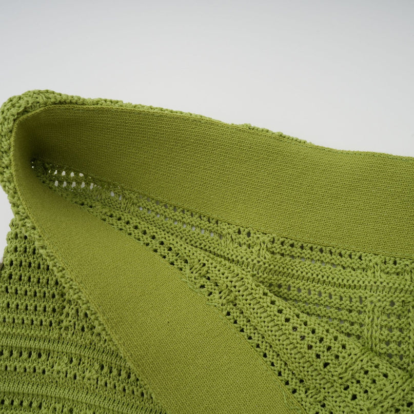 A woman wearing a matching green knit top and skirt set The top features embellishments and the outfit is named Annette The ensemble has a coordinated and elegant appearance