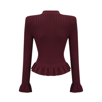 A woman wearing a matching red knit set consisting of a ruffled top and skirt The top features short sleeves and ruffled details while the skirt has a fitted silhouette Both pieces are in a vibrant red color