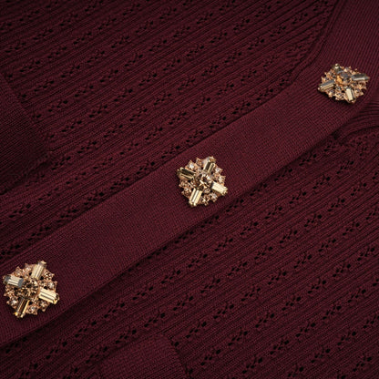 A woman wearing a matching red knit top and skirt set The top has ruffled details and the skirt is form fitting The outfit is called Corrine
