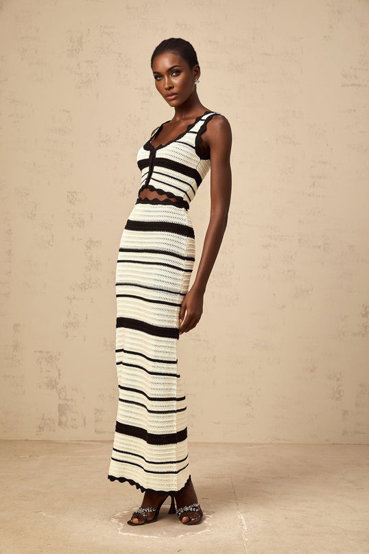 A woman wearing a matching set consisting of a striped vest top and skirt The top features contrasting colors and a sleeveless design The skirt is coordinated with the top creating a cohesive outfit The set is called Avril and showcases a stylish striped pattern