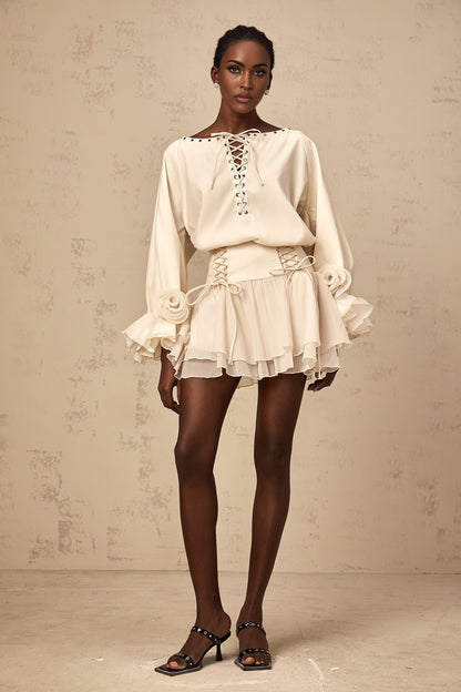 A woman wearing a matching set consisting of a white ruffled blouse with selftie detail and a coordinating skirt the outfit has a feminine and elegant appearance