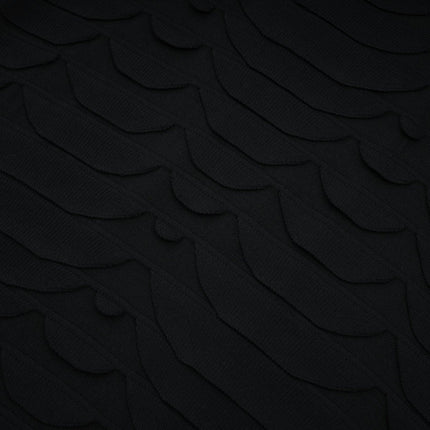 A woman wearing a midi length dress with a snake pattern design and godet flared skirt