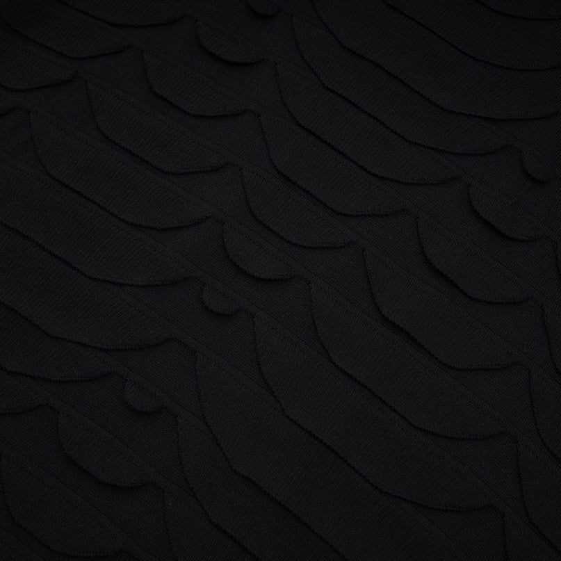 A woman wearing a midi length dress with a snake pattern design and godet flared skirt